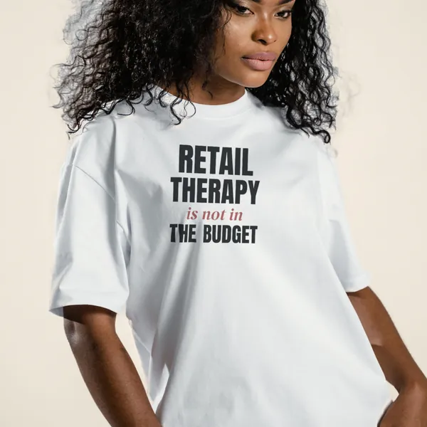 Model wearing a white "Retail Therapy Is Not in the Budget" graphic tee, front view